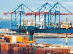 Shipping containers being loaded onto freight boats